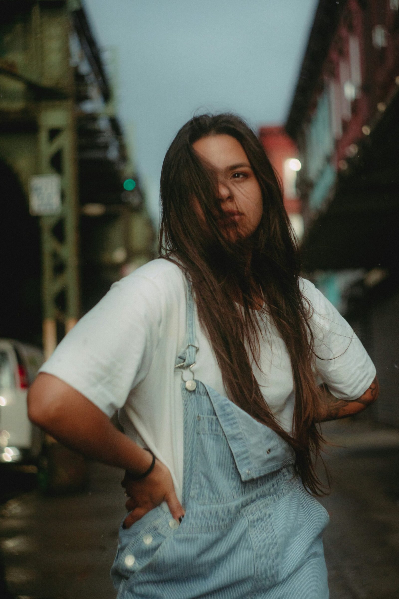 a woman with long hair standing in the street